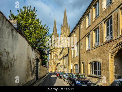 La pittoresca città di Bayeux in Francia nella regione della Normandia con la sua imponente cattedrale gotica della Madonna preso da una strada stretta Foto Stock