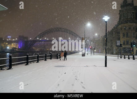 La gente a piedi attraverso il Newcastle Quayside seguenti durante la notte pesante nevicata che ha provocato interruzioni in tutta la Gran Bretagna. Foto Stock