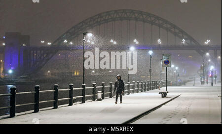 Una persona che cammina attraverso il Newcastle Quayside seguenti durante la notte pesante nevicata che ha provocato interruzioni in tutta la Gran Bretagna. Foto Stock