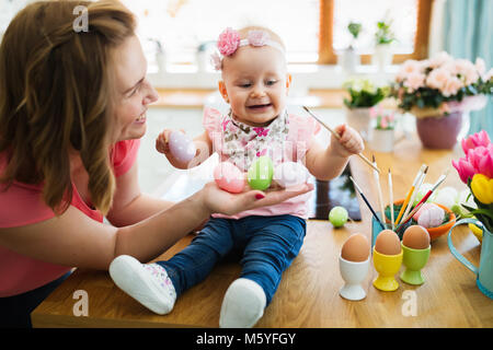 La madre e il suo bambino di pittura delle uova di pasqua Foto Stock