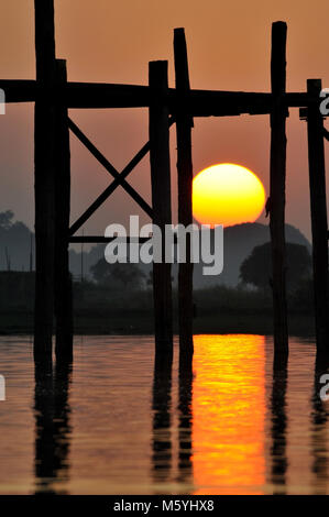 Il teak U Bein Bridge in Amarapura Myanmar durante il tramonto con monaci e biciclette sul ponte Foto Stock