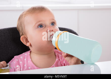 Close-up di un piccolo grazioso Baby girl Acqua Potabile da bottiglia Foto Stock