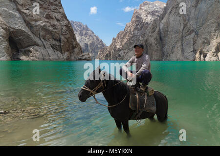 Di Kirghizistan che mostra la sua agilità sul suo cavallo nel lago Köl-Suu, Kurumduk valley, provincia di Naryn, Kirghizistan, Asia centrale Foto Stock