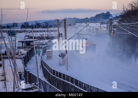 Treno nella neve. C2C convoglio ferroviario in esecuzione attraverso la coperta di neve linee in Chalkwell vicino a Southend on Sea, Essex durante la Bestia da est meteo Foto Stock