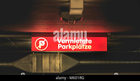 Rosso illuminato in segno di un parcheggio dove è scritto in tedesco affittato parcheggio (vermietete parkplatze) Foto Stock