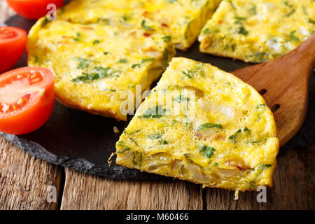 Cucina egiziana: Frittata Igga con verdi, le cipolle e i pomodori vicino sul tavolo orizzontale. Foto Stock