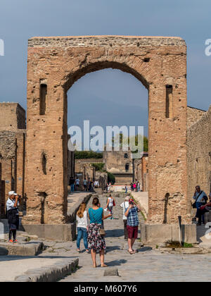 Turisti che fotografano l'arco Onorario a Pompei, in Italia. Foto Stock