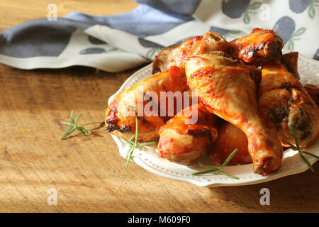 Pollo alla griglia gambe su piastra bianca .cena rustica sfondo. Foto Stock