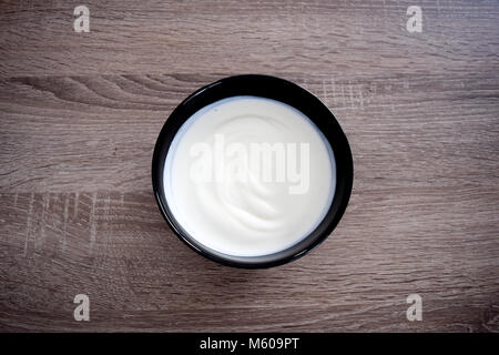 Vaso in ceramica di yogurt bianco isolato su sfondo di legno dal di sopra, Yogurt Yogurt Yogurt Foto Stock