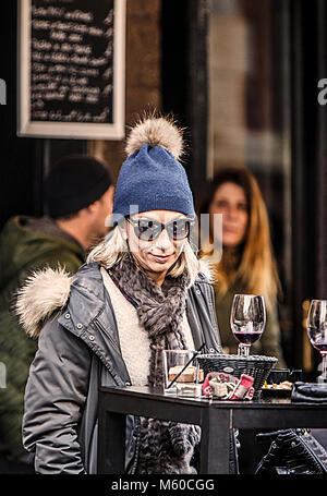 Biarritz, France-February 24,2018: Elegante donna francese gode l'aperitivo sulla terrazza esterna per le strade di Biarritz, Francia. Foto Stock