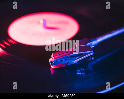 Fono capsula o testa di lettura di un giradischi LP filatura. Chiusura del giradischi stilo vinile andando verso il basso. Riproduzione di inizio di un nero 33 rpm reco Foto Stock