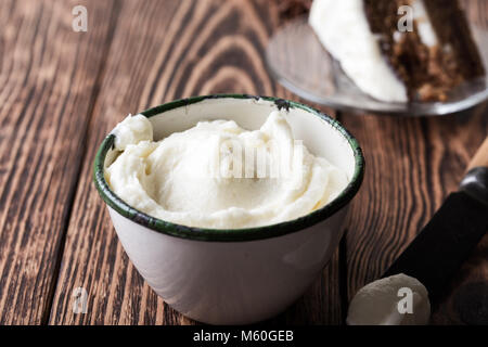 In casa la glassa di formaggio cremoso in tazza rurale su tavola in legno rustico pronto per l'uso Foto Stock