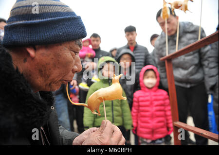 Cangzhou cinese nella provincia di Hebei. Il 27 febbraio, 2018. Un attore folk esegue lo zucchero-figura insufflaggio durante un'attività di salutare la festa delle lanterne nella contea di Suning, nel nord della Cina di nella provincia di Hebei, 27 febbraio 2018. Quest anno la festa delle lanterne cade il 2 marzo. Credito: Yuan Liwei/Xinhua/Alamy Live News Foto Stock