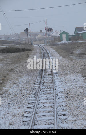 Dungeness, Kent, Regno Unito. 27 feb 2018. La tegola di sputo di Dungeness nel Kent svegliato da una copertura di neve questa mattina in Inghilterra sperimenta un periodo insolitamente freddo questo nel tardo inverno. Fotografia mostra coperta di neve le linee ferroviarie del Romney Hythe e Dymchurch Railway. UrbanImages/Alamy Live News Foto Stock