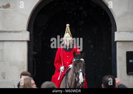 Whitehall, Londra, Regno Unito. Il 27 febbraio, 2018. È montato un bagnino di sentinella all'ingresso delle Guardie a Cavallo come la neve comincia a cadere nel centro di Londra. Credito: Malcolm Park/Alamy Live News. Foto Stock