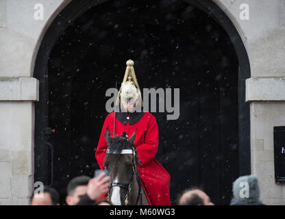 Whitehall, Londra, Regno Unito. Il 27 febbraio, 2018. È montato un bagnino di sentinella all'ingresso delle Guardie a Cavallo come la neve comincia a cadere nel centro di Londra. Credito: Malcolm Park/Alamy Live News. Foto Stock