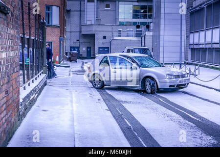 Manchester, Inghilterra. Il 27 febbraio 2018. Regno Unito temperature immergersi come bestia da est porta forti nevicate. Vettura bloccato in giù di neve ghiacciata strada laterale. 'Matthew Walker/Alamy Live News". Foto Stock