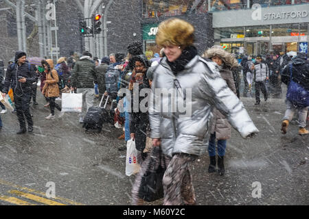 Le persone catturate in forte nevicata a Stratford a Londra, Inghilterra, Regno Unito, Gran Bretagna Foto Stock