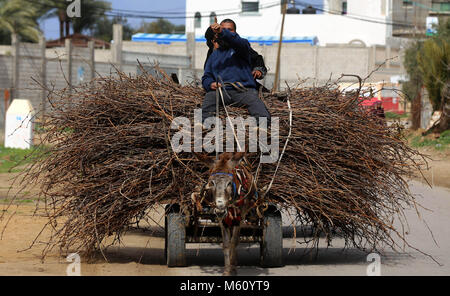 Nusairat, Striscia di Gaza, Territori palestinesi. Il 27 febbraio, 2018. Un uomo palestinese cavalca un asino overstuffed carrello nella zona centrale della striscia di Gaza. Credito: Yasser Qudih APA/images/ZUMA filo/Alamy Live News Foto Stock