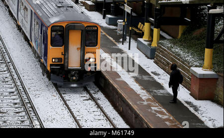 Un treno su strade coperte di neve piste a caccia di Cross Station, Merseyside, a seguito di una notte pesante nevicata che ha provocato interruzioni in tutta la Gran Bretagna. Foto Stock