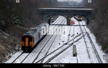 I treni passano sopra coperta di neve le vie vicino a caccia di Cross Station, Merseyside, a seguito di una notte pesante nevicata che ha provocato interruzioni in tutta la Gran Bretagna. Foto Stock