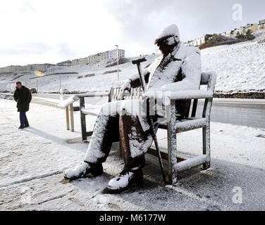 Il Freddie Gilroy scultura coperto di neve a Scarborough North Bay beach, come la nevicata colpisce le strade di tutto il Regno Unito il martedì mattina dopo parecchi centimetri cadde in alcune parti durante la notte. Foto Stock