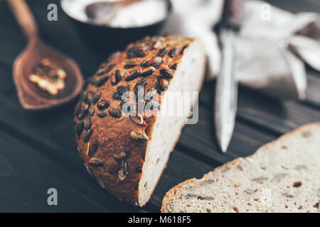 Delizioso pane appena sfornato su sfondo di legno Foto Stock