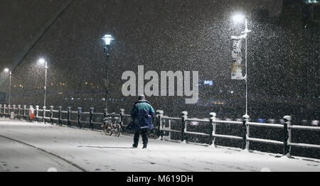 Una persona che cammina attraverso il Newcastle Quayside seguenti durante la notte pesante nevicata che ha provocato interruzioni in tutta la Gran Bretagna. Foto Stock