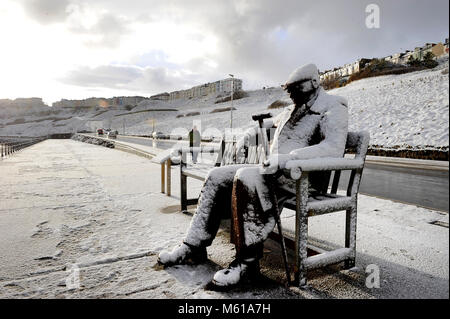 Il Freddie Gilroy scultura coperto di neve a Scarborough North Bay beach, come la nevicata colpisce le strade di tutto il Regno Unito il martedì mattina dopo parecchi centimetri cadde in alcune parti durante la notte. Foto Stock