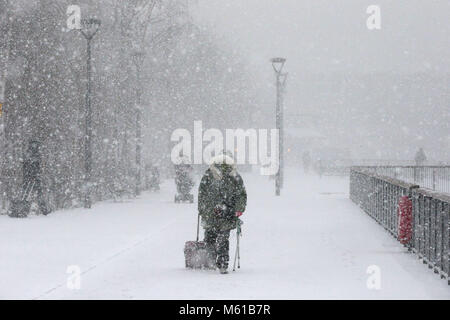 La gente a piedi lungo Bankside nella neve, a Londra, come la nevicata colpisce le strade di tutto il Regno Unito il martedì mattina dopo parecchi centimetri cadde in alcune parti durante la notte. Foto Stock