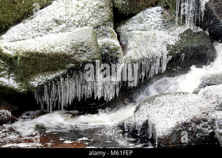 Ghiaccioli sulle rocce al fiume Glencree vicino a Enniskerry, come la nevicata colpisce le strade di tutto il Regno Unito dopo parecchi centimetri cadde in alcune parti per tutta la notte. Foto Stock