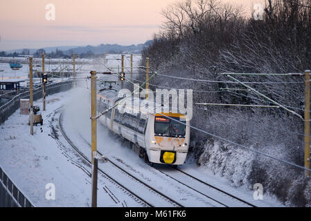 Treno nella neve. C2C convoglio ferroviario in esecuzione attraverso la coperta di neve linee in Chalkwell vicino a Southend on Sea, Essex durante la Bestia da est meteo Foto Stock