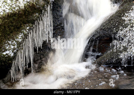 Ghiaccioli sulle rocce al fiume Glencree vicino a Enniskerry, come la nevicata colpisce le strade di tutto il Regno Unito dopo parecchi centimetri cadde in alcune parti per tutta la notte. Foto Stock