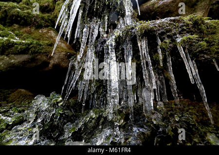 Ghiaccioli sulle rocce al fiume Glencree vicino a Enniskerry, come la nevicata colpisce le strade di tutto il Regno Unito dopo parecchi centimetri cadde in alcune parti per tutta la notte. Foto Stock