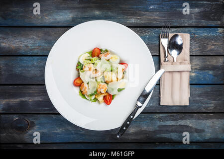 Fresca insalata caesar sulla piastra bianca con formaggio parmigiano e gamberetti. Vista superiore Foto Stock