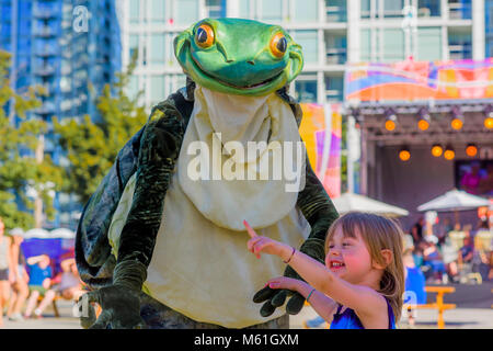 Bobina mortale stoppino attori in costume di rana interagisce con la bambina , Larwill Park, Vancouver, British Columbia, Canada. Foto Stock