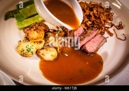 Piatto gourmet in Hotel Schiff a Hittisau, Austria. La raccomandazione della giornata: Arrosto di cipolla dal macellaio Fetz con piselli kaiser e patate arrosto Foto Stock