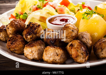 Le polpette di carne arrosto con patate sul tavolo di legno Foto Stock