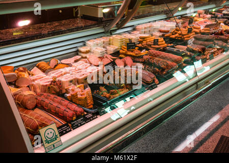 Vetrina refrigerata con salsicce e insalate nella macelleria con elite smiley, controllo degli alimenti Foto Stock