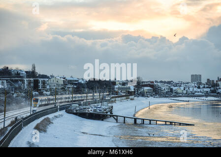 Treno nella neve. C2C convoglio ferroviario in esecuzione attraverso la coperta di neve linee in Chalkwell vicino a Southend on Sea, Essex. Bestia da est. Neve sulla spiaggia Foto Stock