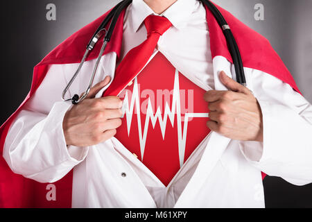 Close-up di supereroe medico maglietta di apertura per mostrare segni di Heartbeat Foto Stock