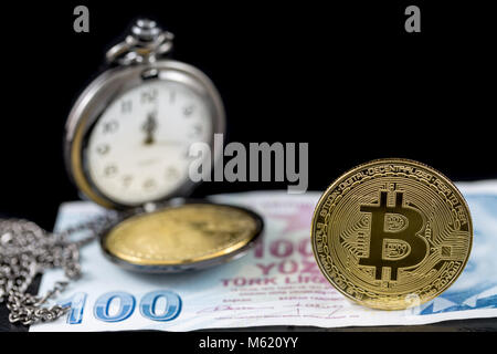 Bitcoin e orologio da tasca su un centinaio di lira turca con sfondo nero Foto Stock