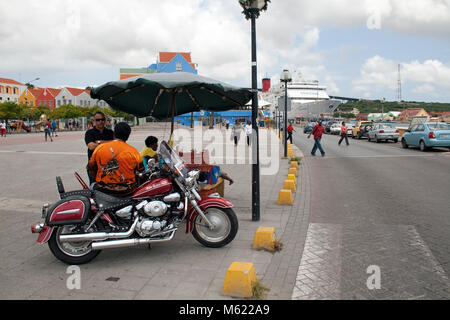 Uomo sulla bici del motore in corrispondenza di un venditore ambulante, Otrobanda distretto, Willemstad, Curacao, Antille olandesi, dei Caraibi Foto Stock