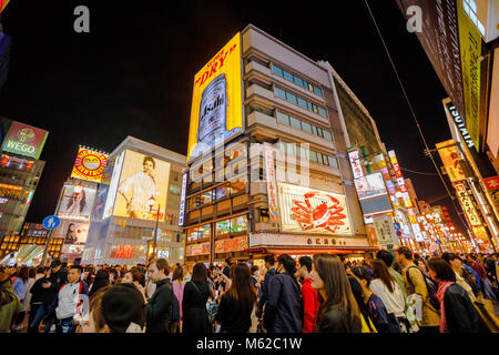 Osaka, Giappone - 29 Aprile 2017: folla di persone per settimana d'Oro in area Dotonbori con Kani granchio Doraku segno del popolare ristorante Giapponese. Quartiere Namba di notte. Foto Stock