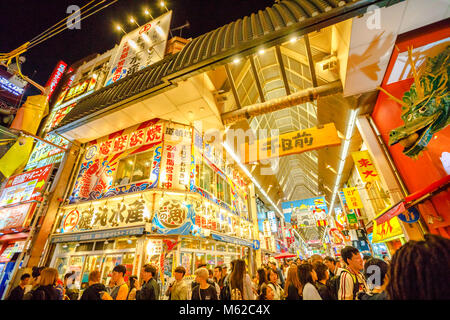 Osaka, Giappone - 29 Aprile 2017: folla di persone per settimana d'oro in entrata di Ebisu Bashi-Suji Shopping Street con le sue luci al neon colorate nel quartiere Namba, una delle principali destinazioni turistiche di Osaka. Foto Stock