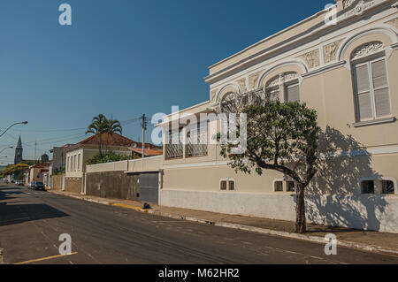 São Manuel, a sud-est del Brasile. Vecchia casa cittadina in un vuoto di strada con alberi sul marciapiede in una giornata di sole a São Manuel. Un grazioso paese di campagna. Il Brasile. Foto Stock