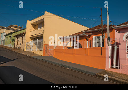 São Manuel, a sud-est del Brasile. Di classe operaia case colorate e recinzioni in un vuoto di strada in una giornata di sole a San Manuel. Un incantevole piccola cittadina di campagna. Foto Stock