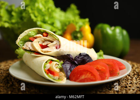 Shaurma senza salsa con pollo, pepe, lattuga. A basso contenuto di calorie da rotolo di pane pita, accanto al basilico viola e fette di pomodoro. Senza la tostatura, Foto Stock