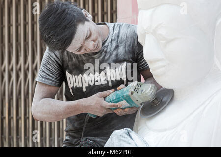 Uomo locale scultura in marmo del Buddha, Amarapura, Mandalay Myanmar (Birmania), l'Asia in febbraio - lavorare in marmo scultura in pietra workshop coperti di polvere Foto Stock