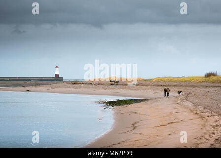 Una madre e figlia una passeggiata lungo una spiaggia vicino alla bocca del fiume Tweed su un pomeriggio invernale, Berwick upon Tweed, Northumberland,l'Inghilterra,UK Foto Stock